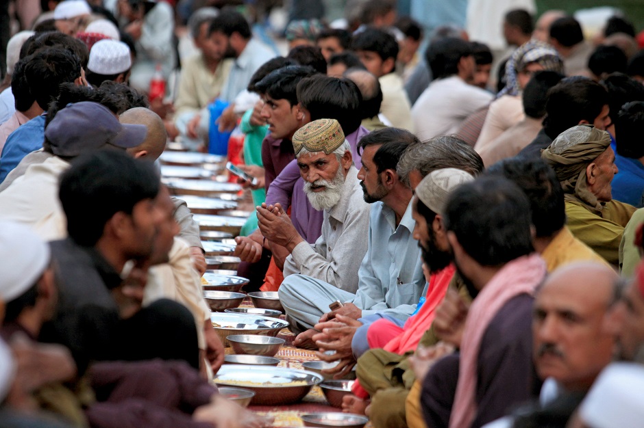 People wait before breaking their fast in Rawalpindi. PHOTO: REUTERS