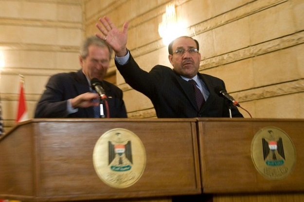 A file picture dated December 14, 2009 shows Iraq's Prime Minister Nuri al-Maliki (R) trying to protect then US President George W Bush after Iraqi journalist Muntazer al-Zaidi threw his shoes at Bush during a press conference in Baghdad. PHOTO: AFP