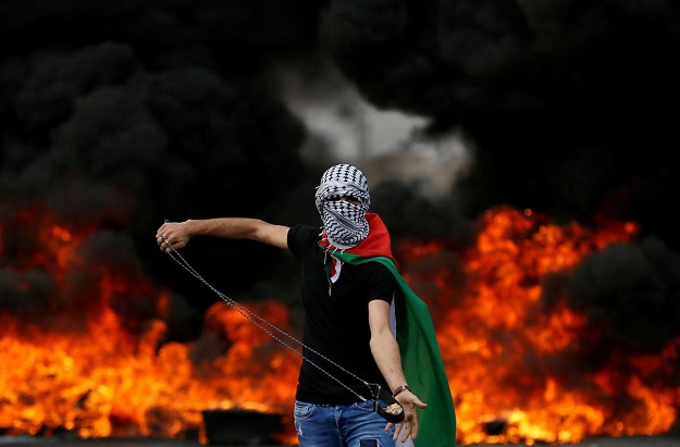 A Palestinian demonstrator holds a sling during a protest marking the 70th anniversary of Nakba, near the Jewish settlement of Beit El, near Ramallah, in the occupied West Bank May 15, 2018. REUTERS/Mohamad Torokman