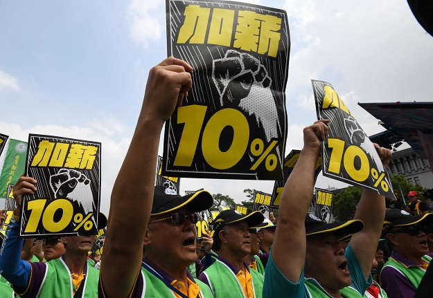 PHOTO: Members of a local labour union display placards asking for higher wages during the annual May Day rally in Taipei on May 1, 2018. 