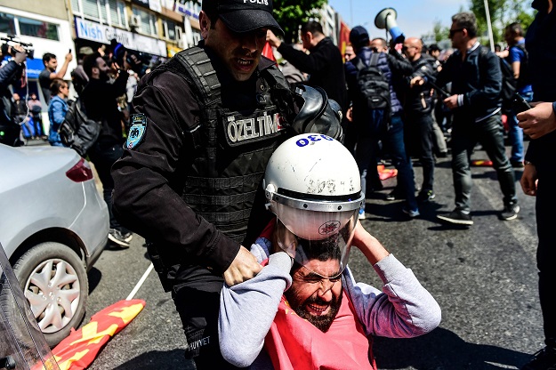 Turkish police officers arrest a protester attempting to defy a ban and march on Taksim Square to celebrate May Day on May 1, 2018 in Istanbul PHOTO: AFP