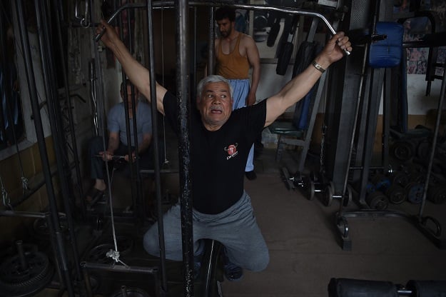 Afghan bodybuilder Aziz Arezo, 61, exercising at his bodybuilding gym in Kabul. PHOTO: AFP