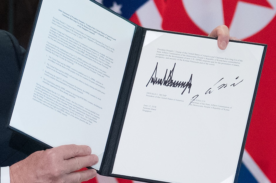 US President Donald Trump holds up a document signed by him and North Korea's leader Kim Jong Un following a signing ceremony during their historic US-North Korea summit, at the Capella Hotel on Sentosa island in Singapore on June 12, 2018. PHOTO: AFP