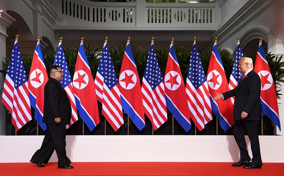 US President Donald Trump (R) and North Korea's leader Kim Jong Un (L) walk toward one another at the start of their historic US-North Korea summit. PHOTO: AFP