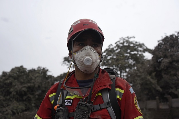A firefighter is pictured during search operations at the ash-covered village of San Miguel Los Lotes, in Escuintla department, about 35 km southwest of Guatemala City, on June 4, 2018, a day after the eruption of the Fuego Volcano. Rescue workers Monday pulled more bodies from under the dust and rubble left by an explosive eruption of Guatemala's Fuego volcano, bringing the death toll to at least 62. PHOTO: AFP