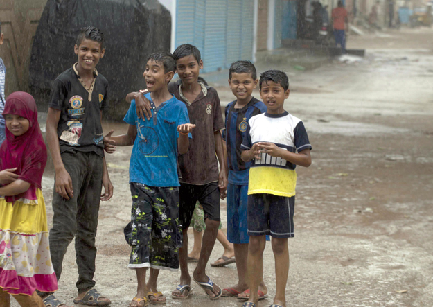 Children came out on streets to enjoy summer rain. PHOTO: MOHAMMAD AZEEM