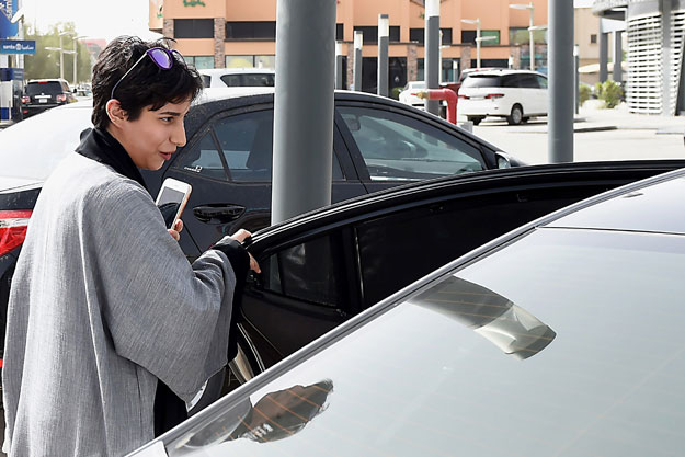 A Saudi female customer gets into the car of Reem Farahat, a female employee of Careem, a chauffeur car booking service, in Riyadh. PHOTO: AFP