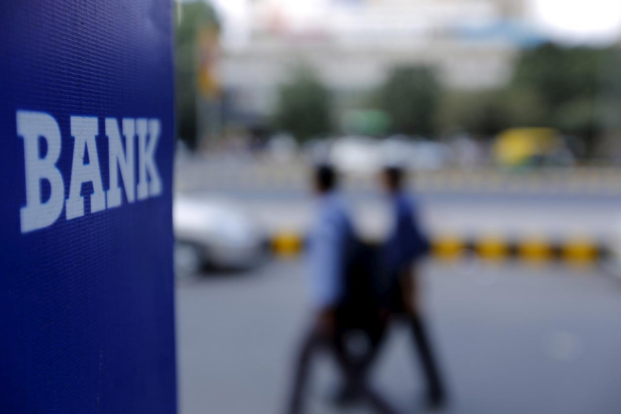 file-photo-commuters-walk-past-a-bank-sign-along-a-road-in-new-delhi-2