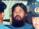 japanese-doomsday-cult-leader-shoko-asahara-sits-in-a-police-van-following-an-interrogation-in-tokyo