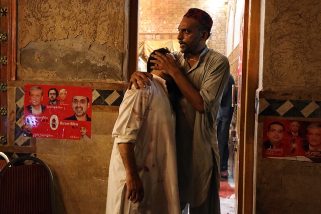   A party worker comforts another after the attack that killed at least 20 people. PHOTO: REUTERS 