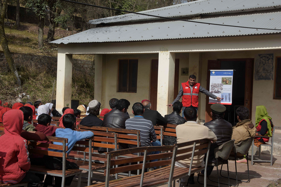 An official of the Pakistan Red Crescent Society (PRCS) leading an awareness campaign for landmines to local residents in Abbaspur Sector. PHOTO: AFP.