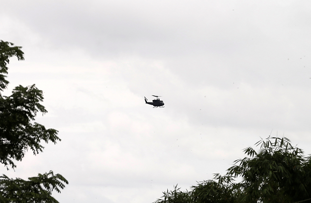 Military helicopter hovers near the Tham Luang cave complex. PHOTO:REUTERS