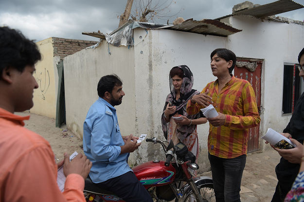 Pakistani transgender independent candidate Nadeem Kashish (R), who will contest in the general election for a parliamentary seat, distributes pamphlets on the campaign trail in her constitutency in Islamabad. PHOTO:AFP PHOTO:AFP