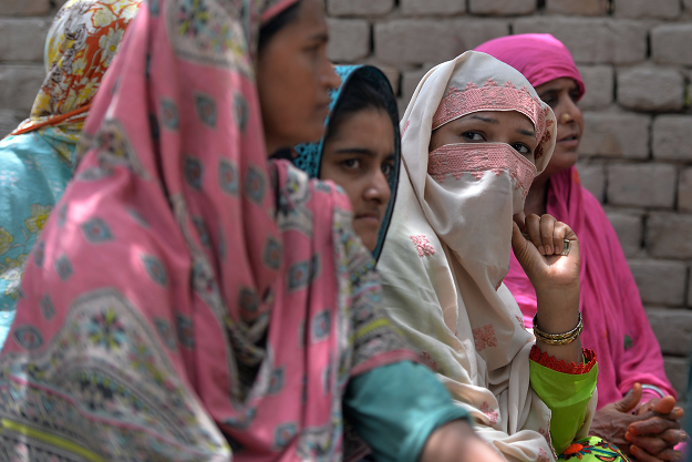 Pakistani villagers, who never voted in past general elections, listen to a Pakistani social worker and member of district council. PHOTO:AFP