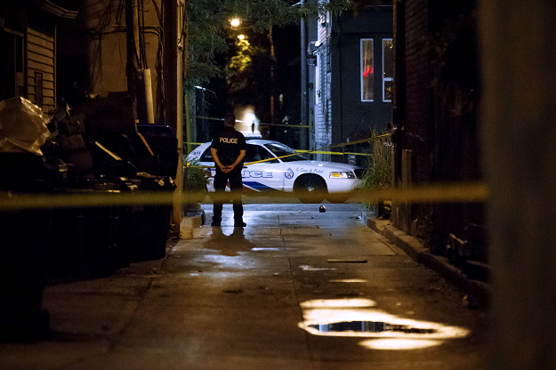 A Toronto Police Officer stands watch at Danforth St. at the scene of a shooting in Toronto. PHOTO:AFP