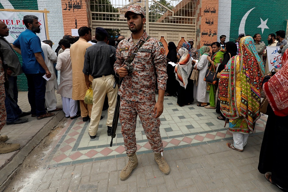  Ranger stands to guard electoral workers, who gather to collect election materials, ahead of general election in Karachi. PHOTO: REUTERS