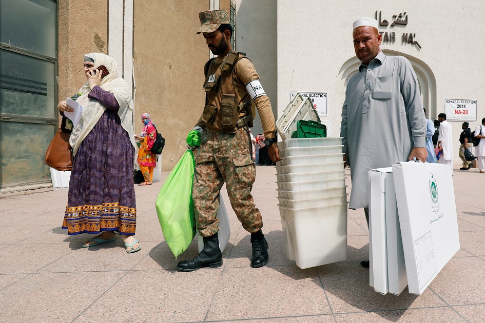 Soldier helps electoral workers after collecting election materials from a distribution point. PHOTO: REUTERS