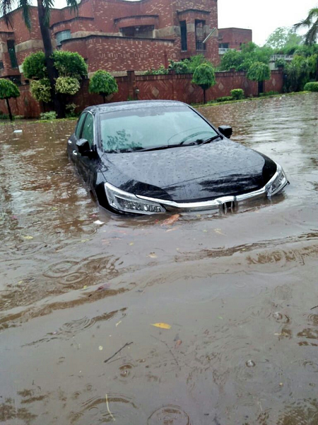 A car is surrounded by water. PHOTO: EXPRESS/ M. Shehzad.