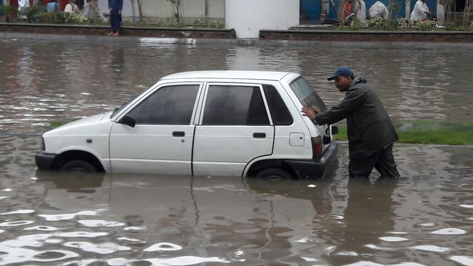 A man pushes his car on a flooded road in Lahore. PHOTO: EXPRESS/ M. Shehzad. 