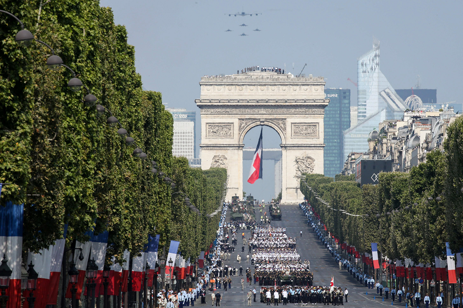 A general view shows military planes and regiments taking part in the annual Bastille Day military parade on the Champs-Elysees avenue near the Arc de Triomphe in Paris. PHOTO: AFP.