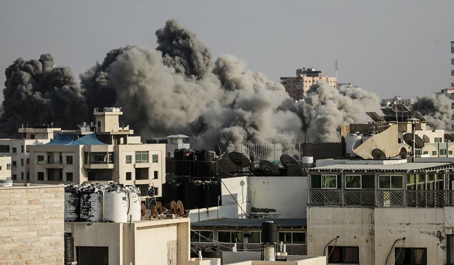 Smoke rises above buildings during an Israeli air strike on Gaza City on July 14, 2018.  Israel's military renewed air strikes targeting Hamas in the Gaza Strip today. PHOTO: AFP