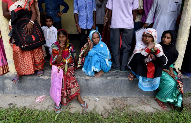 Villagers wait outside the National Register of Citizens (NRC) centre to get their documents verified by government officials. PHOTO:REUTERS
