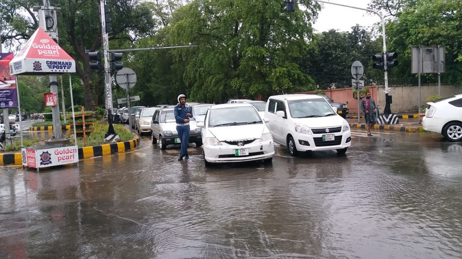 Cars parked at a signal as the rain pours. PHOTO: EXPRESS/ M. Shehzad.