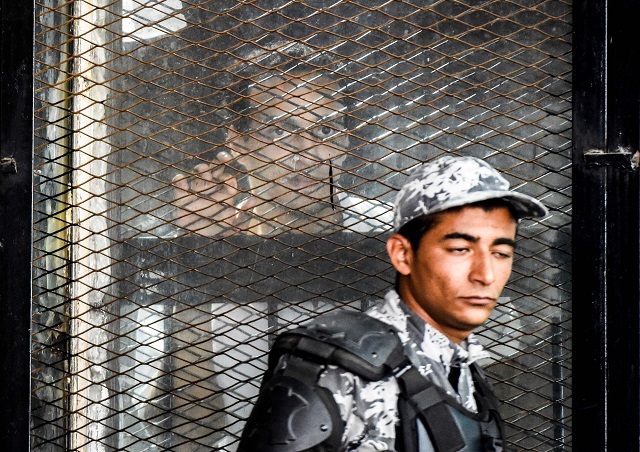 Egyptian photographer Mahmoud Abdel Shakour Abouzied (C), also known as Shawkan, is seen inside a soundproof glass dock during his trial in the capital Cairo on July 28, 2018. PHOTO: REUTERS