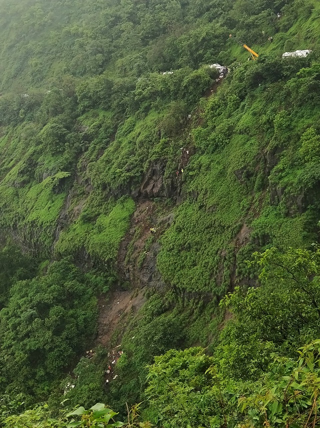 A crane is seen at a mountain road during a rescue operation after a bus fell into a valley near Mahabaleshwar in India's Maharashtra state on July 28, 2018. PHOTO: AFP