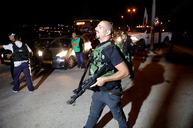 A security guard walks into the Israeli settlement Adam after a Palestinian assailant stabbed three people and then was shot and killed, according to the Israeli military. PHOTO: REUTERS