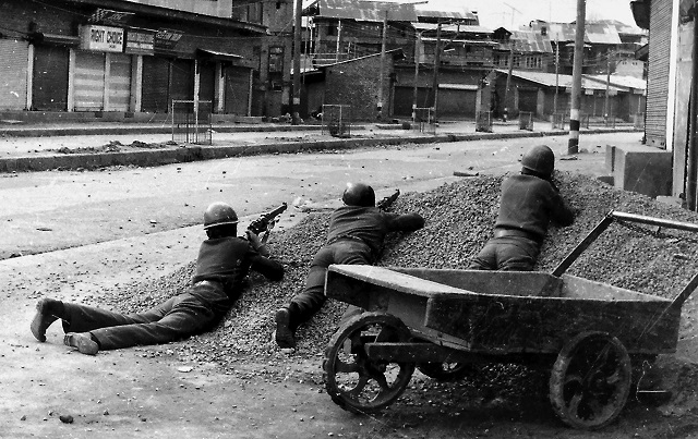 This photograph taken in 1989 shows Indian policemen taking positions after Kashmiri militants opened fire on government forces in the old city area of Naid Kadal in Srinagar. PHOTO: AFP