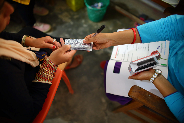 Nepali health worker giving free medicine to a pregnant woman at a health centre in the Ramechhap district. PHOTO: AFP.