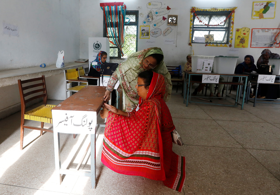 Officials prepare a polling station before voting start during general election in Rawalpindi. PHOTO: REUTERS.