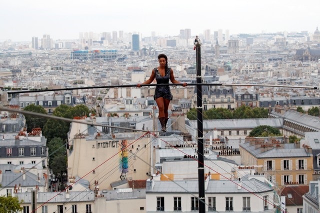 Tightrope walker Tatiana-Mosio Bongonga advances on a tightrope as she scales the Monmartre hill towards the Sacre Coeur Basilica (not pictured) in Paris, France, July 20, 2018. REUTERS.