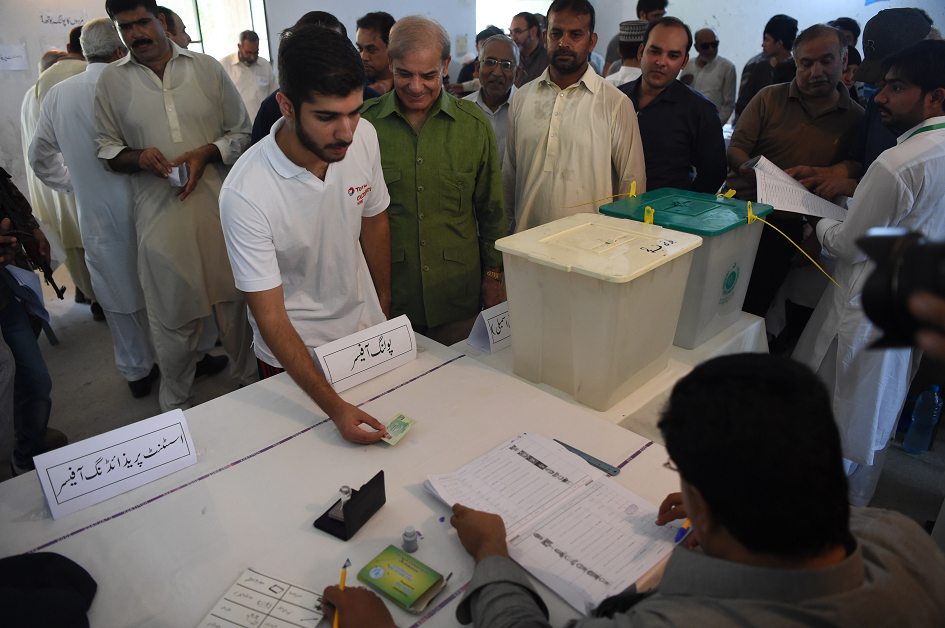 Shahbaz Sharif stands in a queue before voting. PHOTO: AFP.