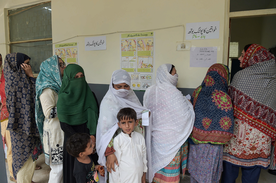 Women stand in a queue as they wait to cast their vote at a polling station in Islamabad. PHOTO: AFP.