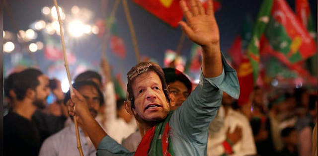 A supporter of Imran Khan, chairman of the Pakistan Tehreek-e-Insaf (PTI), political party, wears a mask and dance on party songs during a campaign rally ahead of general elections. PHOTO:REUTERS