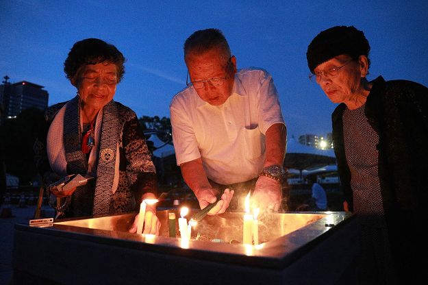 Family members offer prayers for the atomic bomb victims at the Peace Memorial Park in Hiroshima. PHOTO:AFP