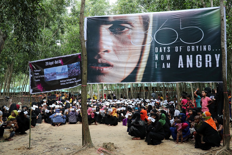 Banners are seen as Rohingya refugee women take part in the protest.