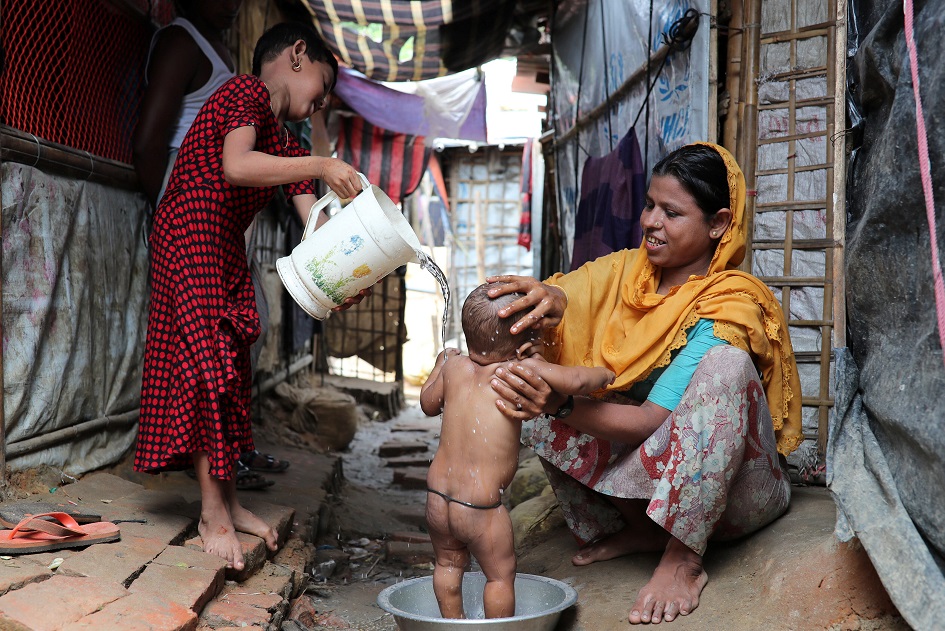 Rashida Begum, a Rohingya refugee woman bathes her son in the Kutupalong camp in Cox's Bazar, Bangladesh. PHOTO: REUTERS