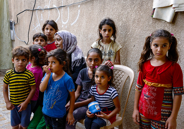 Sana Ibrahim  sits with her family in a courtyard in their home in the northern city of Mosul. PHOTO:AFP