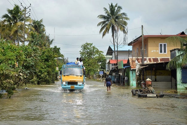 A mini-truck makes its way down a flooded road in Paravur on the outskirts of Kochi in the south Indian state of Kerala, India. PHOTO: AFP