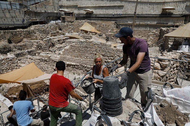 Israeli archeologists work at the site where a rare golden earring believed to be more than 2,000 years-old, discovered at the archeological site of the City of David in East Jerusalem near the walls of the old city on 8 August 2018. PHOTO: AFP