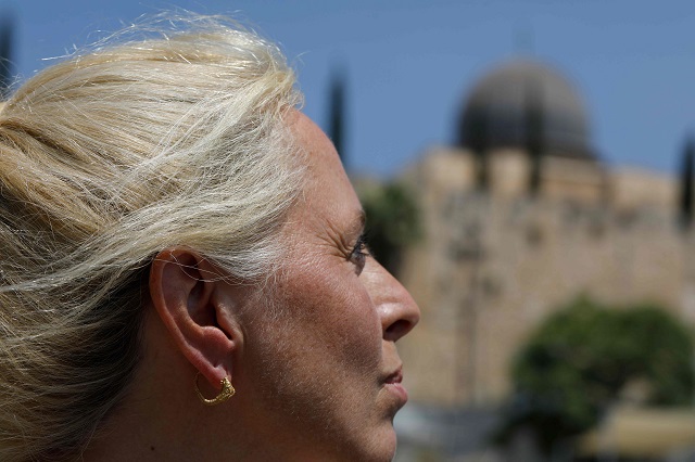 Professor Cayetana Johnson wears a rare golden earring believed to be more than 2,000 years-old, discovered at the archeological site of the City of David in East Jerusalem near the walls of the old city on 8 August 2018. PHOTO: AFP