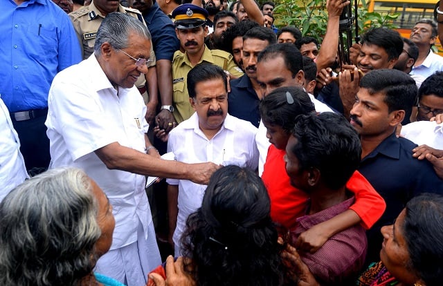 Kerala Chief Minister Pinarayi Vijayan (L) along with opposition leader Ramesh Chennithala (2L) visit a relief camp in Chengamanadu Government Higher Secondary School (HSS) in Ernakulam district of Kochi, in the Indian state of Kerala on August 11, 2018. PHOTO: AFP