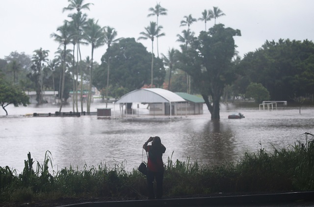 AUGUST 23: A woman takes photos of floodwaters from Hurricane Lane rainfall on the Big Island on August 23, 2018. PHOTO: AFP