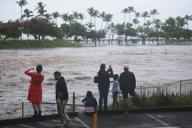 AUGUST 23: People gather to watch and take photos of floodwaters from Hurricane Lane rainfall on the Big Island on August 23, 2018 in Hilo, Hawaii. PHOTO: AFP