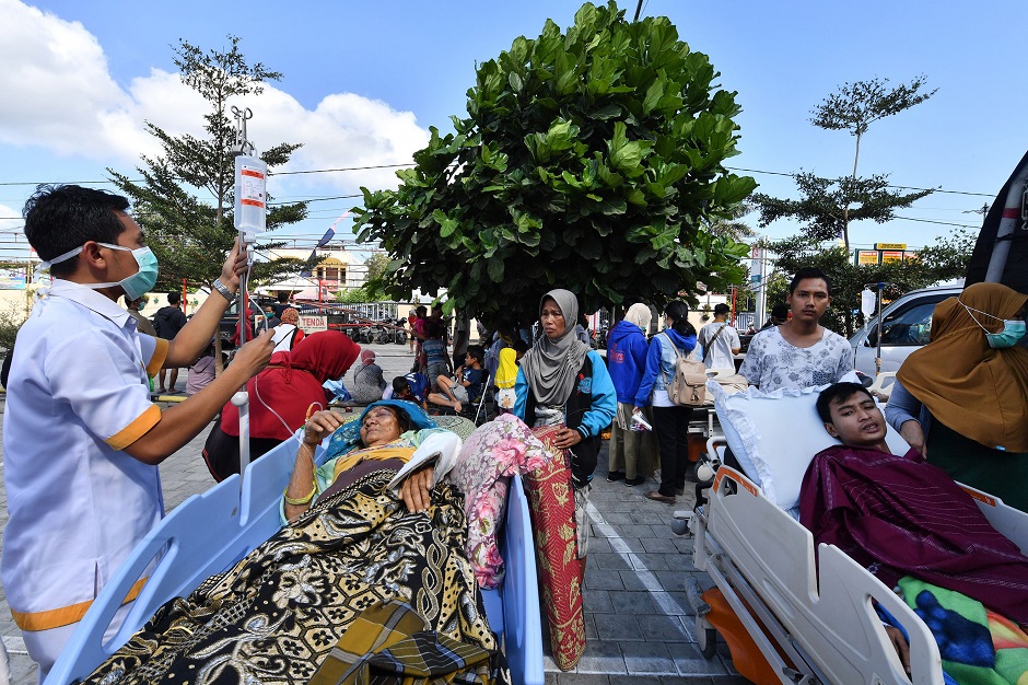 1.People receive medical assistance at a makeshift ward set up outside the Moh. Ruslan hospital in Mataram on the Indonesian island of Lombok on August 6, 2018, the morning after a 6.9 magnitude stuck the island. Indonesian security forces and emergency workers raced on August 6 to rescue survivors of the powerful earthquake on Lombok that killed at least 82 people, as strong aftershocks sparked terror on the holiday island that suffered another deadly quake just a week ago. PHOTO: AFP