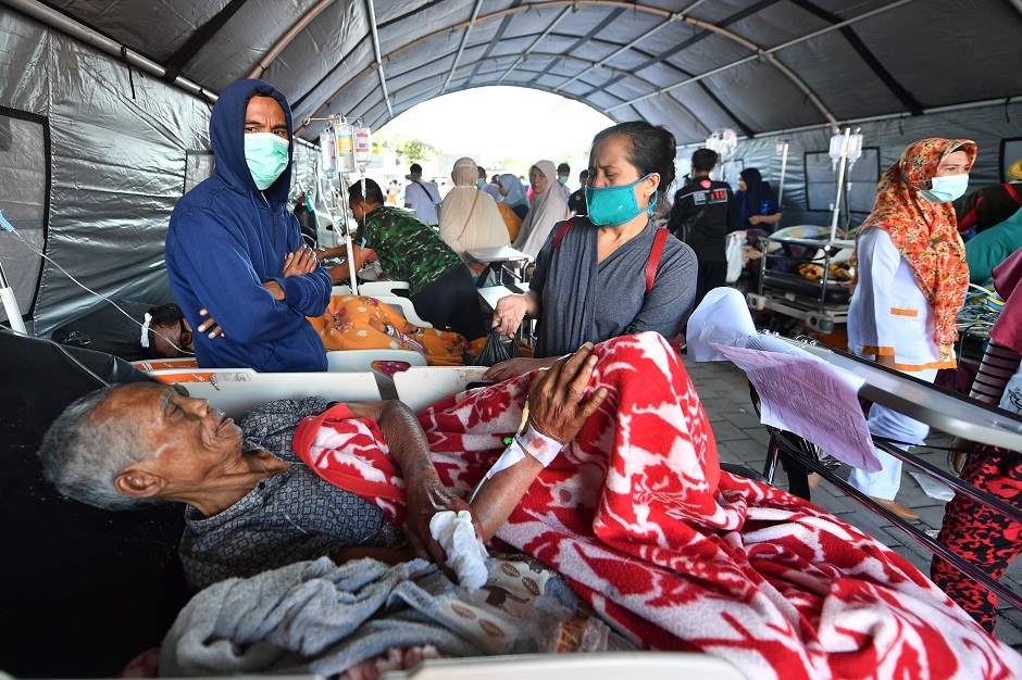 2.An elderly man rests in a hospital bed at a makeshift ward set up outside the Moh. Ruslan hospital in Mataram on the Indonesian island of Lombok on August 6, 2018, the morning after a 6.9 magnitude stuck the island. Indonesian security forces and emergency workers raced on August 6 to rescue survivors of the powerful earthquake on Lombok that killed at least 82 people, as strong aftershocks sparked terror on the holiday island that suffered another deadly quake just a week ago. PHOTO: AFP