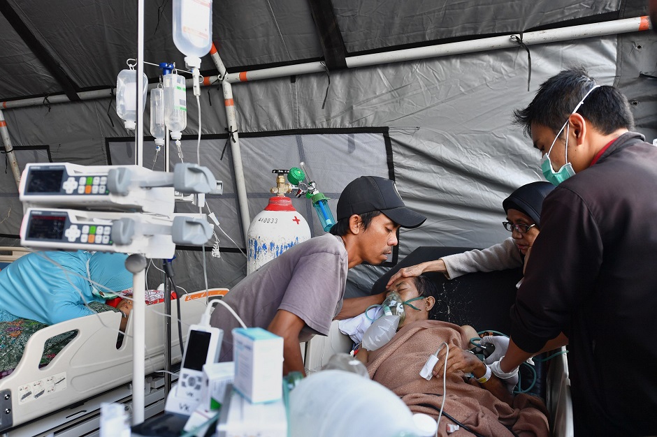 3.A patient receives medical help at a makeshift ward set up outside the Moh. Ruslan hospital in Mataram PHOTO: AFP